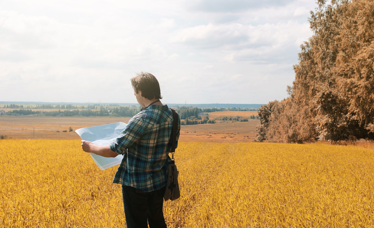 A young man looks at a map autumn season